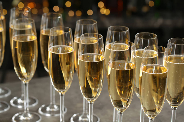 Glasses of champagne against blurred lights. Bokeh effect - Фото, изображение
