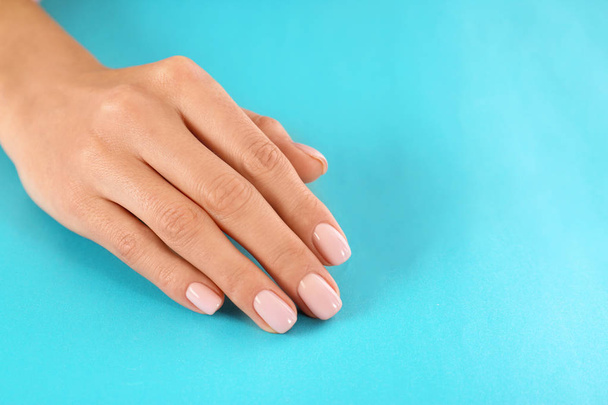 Beautiful female hand on color background, closeup with space for text. Spa treatment - Fotó, kép