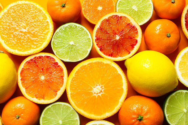 Different citrus fruits on color background, top view - Fotografie, Obrázek