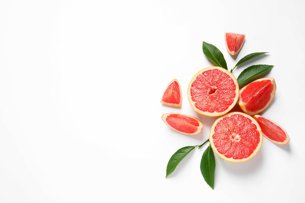Grapefruits and leaves on white background, top view. Citrus fruits - Foto, Bild