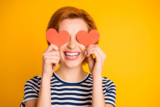 Close-up portrait of her she nice-looking attractive cheerful cheery optimistic girl closing eyes with two small little heart shapes hiding isolated over bright vivid shine yellow background - Photo, image