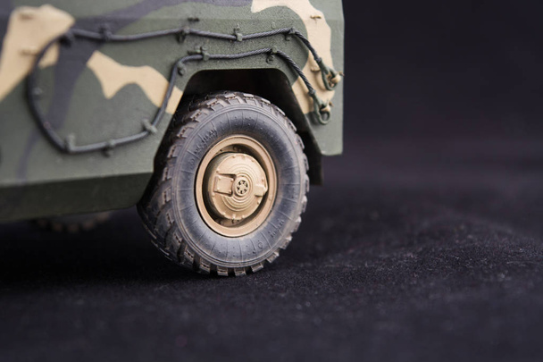 Russian military armored camouflage jeep Tiger. Closeup view. Plastic scale model on dark background - Photo, Image