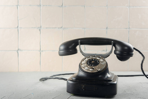 Black vintage phone against the wall with ceramic tiles - Foto, Imagem