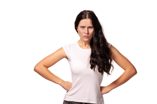 Angry girl standing with hands on waist and looking at camera - Photo, Image