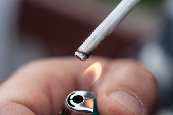 Closeup of a man's hand lights a cigarette with lither - Фото, зображення