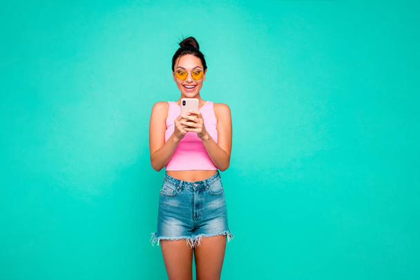 Close up photo beautiful funky hairstyle she her lady hold hands arms telephone reader sale discount shopping notification wear casual tank-top jeans denim shorts isolated teal turquoise background - Valokuva, kuva