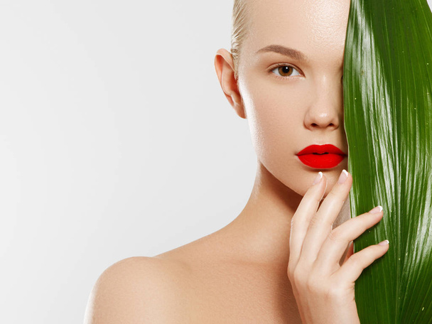 Skincare, Wellness, Spa. Clean soft Skin, healthy Fresh look. The concept of a healthy skin. Portrait of a beautiful girl against a background of tropical leaves. Spa concept. Natural beauty - Photo, Image