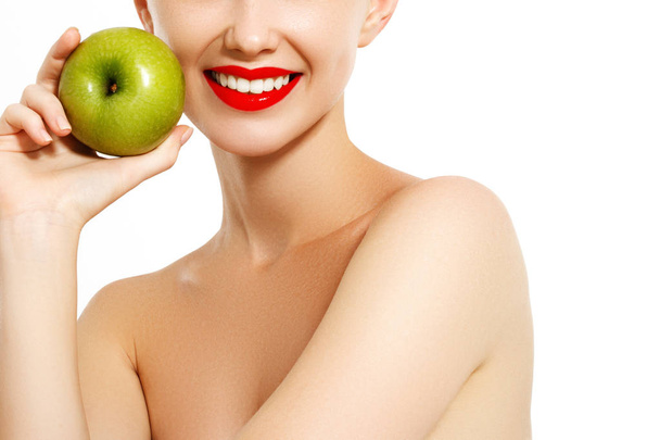 Sağlıklı bir diyet yemek. Güzel mutlu gülümseyen genç kadın ile mükemmel bir gülümseme, beyaz dişler ve taze yüz organik yeşil elma tutan closeup portresi. Diş sağlığı kavramı. Yüksek çözünürlüklü görüntü - Fotoğraf, Görsel