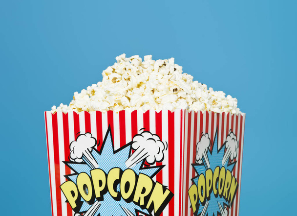 Basket of Popcorn on blue background - 写真・画像