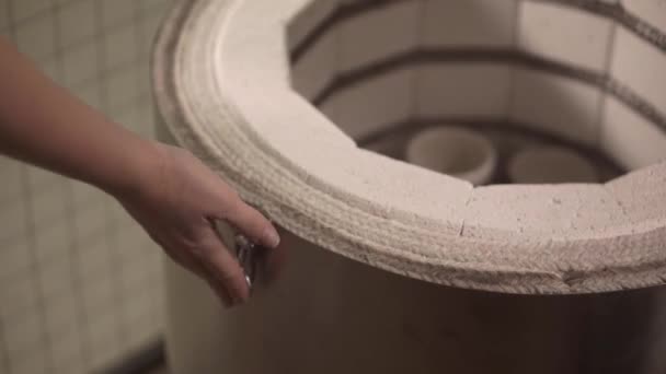 Meister öffnet modernen Töpferofen und nimmt fertige Keramikwaren - Filmmaterial, Video