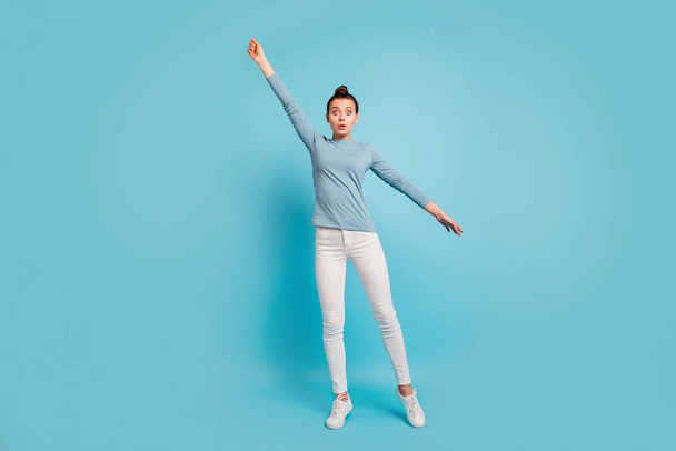 Full length body size view photo cute charming lady astonished impressed incredible frightened fear try catch holiday fly dressed cotton pullover white trousers sneakers isolated blue background  - Foto, Bild