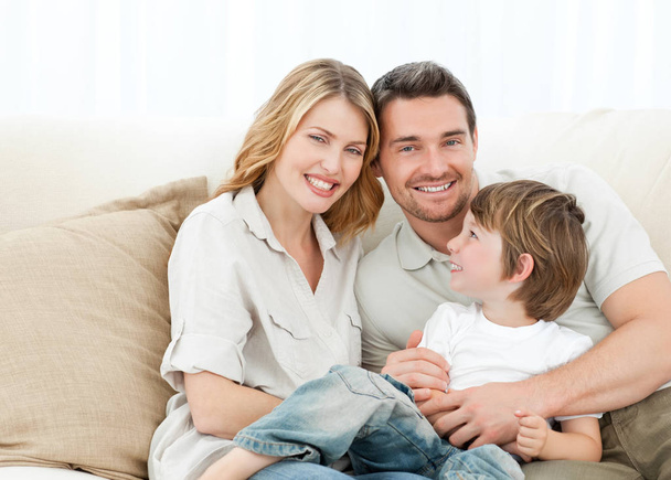 Happy family on their sofa at home - Фото, зображення