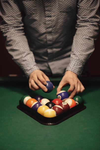 American billiard poule. Triangle of billiard balls. A man getting ready to start a game of billiards. - Foto, Bild