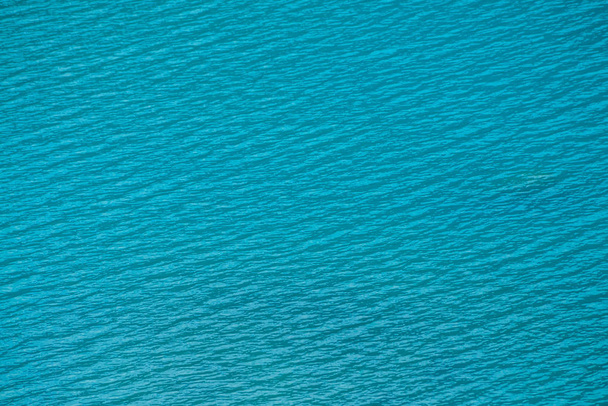 Amazing textured background of calm azure clean water surface. Sunshine in mountain lake close up. Beautiful ripples on shiny water in sunny day. Wonderful relax texture. - Photo, image
