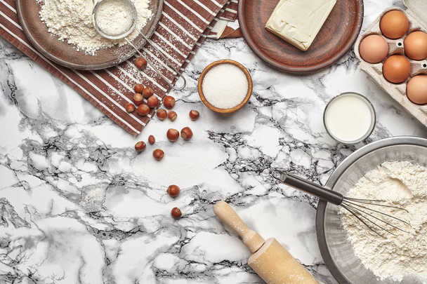 Close-up shot. Top view of a baking ingredients and kitchenware on the marble table background. - Foto, Imagen