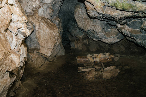 Ωραία σπηλιά. Θέα από το εσωτερικό σκοτεινό μπουντρούμι. Με υφή τοίχους σπηλαίου. Φόντο της υπόγειας σήραγγας. Υγρασία μέσα στο σπήλαιο. Κατοικία πρωτόγονων σπηλαίων. - Φωτογραφία, εικόνα