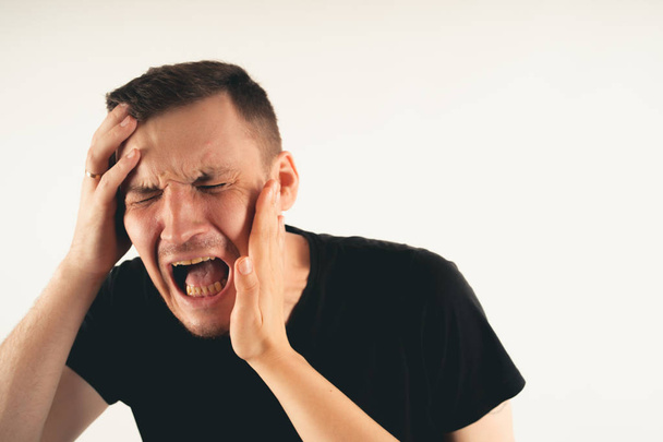 Crop person slapping scared man in faceEmotional male getting slapped in face while shouting with closed eyes in fear on white background - Photo, Image