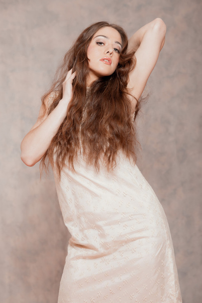 Sensual fashion woman with long hair. Wearing beige dress. Marbl - Photo, Image