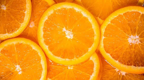 テクスチャの背景としてスライスされた新鮮なオレンジをクローズアップ - 写真・画像
