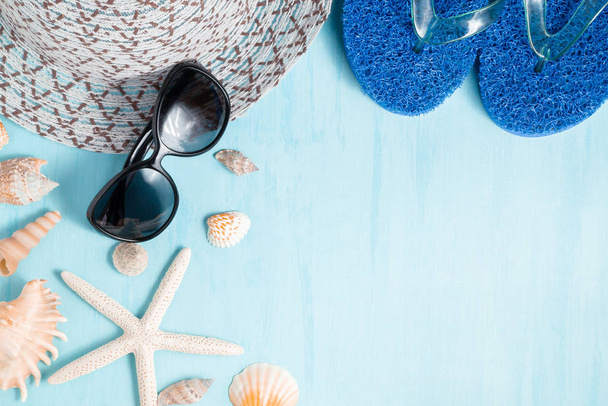 Blue sea background with hat, sunglasses and seashells, summer holiday and vacation time concept - Foto, Imagem