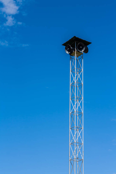 Speakers on the metal pole tower for announcement with blue sky background - Fotoğraf, Görsel