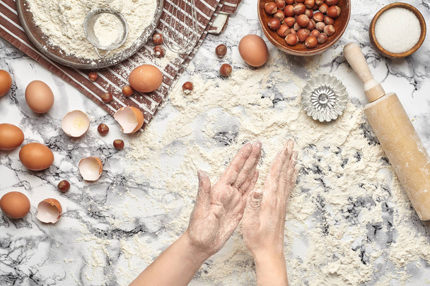 Lähikuvaa. Top näkymä leipuri kokki paikka, kädet työskentelevät raaka taikina marmoripöydän taustalla
. - Valokuva, kuva