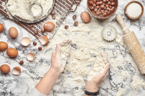 Gros plan. Vue de dessus d'un lieu de cuisson boulanger, les mains travaillent avec une pâte crue sur le fond de la table en marbre
. - Photo, image