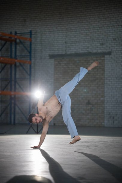 Un atlético entrenado en capoeira a punto de dar la vuelta
 - Foto, Imagen