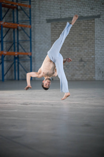 Een atletische man op Capoeira training. Flip in beweging - Foto, afbeelding