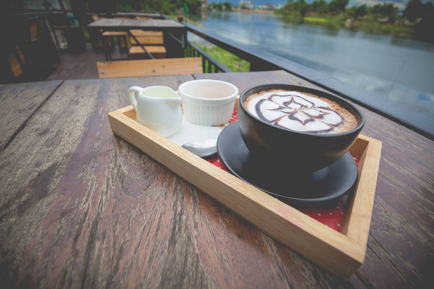 hot coffee with foam milk art. Black cup of coffee. Hot coffee i - Foto, afbeelding