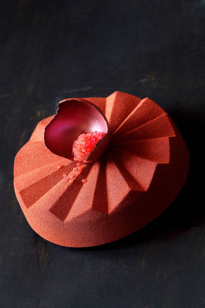 Çağdaş Çikolata Mousse Kek geometrik silikon kalıp yapılmış, tuğla rengi kadife sprey ile kaplı ve çikolata kabuğu kan portakal havyar ile dolu süslenmiş, siyah arka plan üzerinde. - Fotoğraf, Görsel