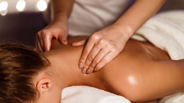 Дівчина насолоджується терапевтичним масажем шиї в спа-центрі
 - Фото, зображення
