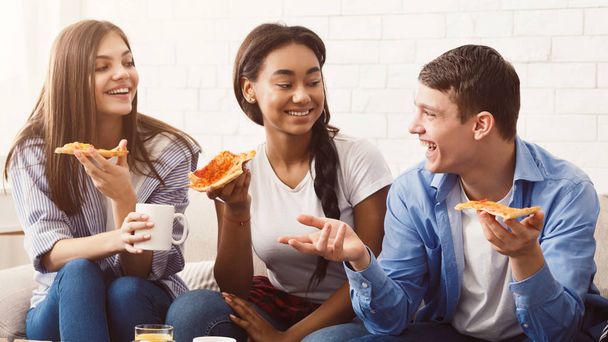Pizza idő. Barátok eszik és beszél otthon - Fotó, kép