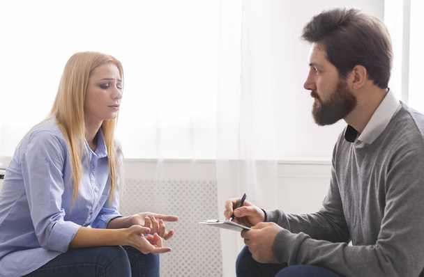 Psychoanalist luisteren naar depressieve vrouw praten over haar problemen - Foto, afbeelding