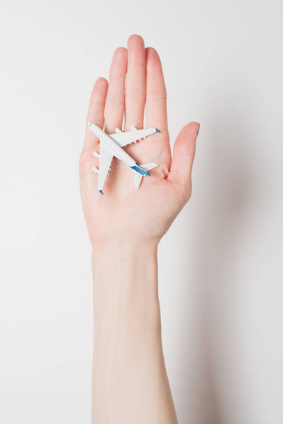 Airliner sul palmo della mano femminile su uno sfondo chiaro. Concetto di voli sicuri
 - Foto, immagini