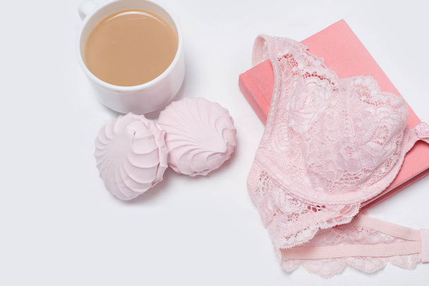 Csésze kávé marshmallows. Pink csipke prímás és Jegyzettömb fehér háttérrel. Divatos koncepció. - Fotó, kép
