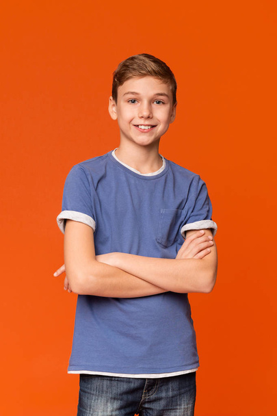adolescent garçon avec les mains pliées sur orange fond
 - Photo, image