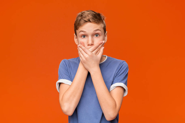 Portrait of stunned boy on orange studio background - Photo, Image