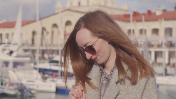 Townswoman güneşli baharda modern yatların yakınındaki limanda yolda yürüyor - Video, Çekim