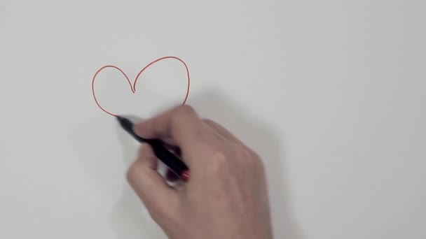 male hand draws two hearts on a white sheet - Video, Çekim