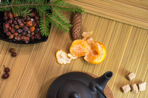 New Year's and Christmas. Decorative set of dog rose, mandarin, spruce branch, teapot. View from above - Photo, Image