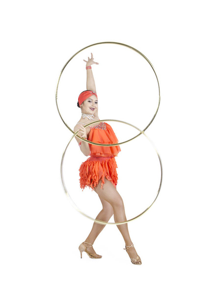 A girl in a stage dress performs a dance with a hula Hoop. - Foto, Bild