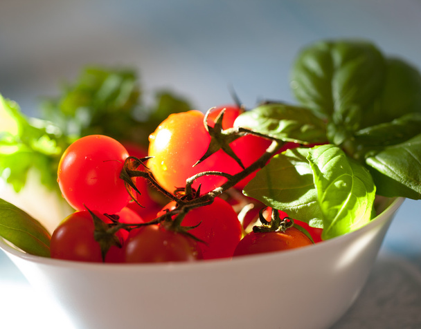 Tomates cherry frescos en un elegante tazón blanco
. - Foto, imagen
