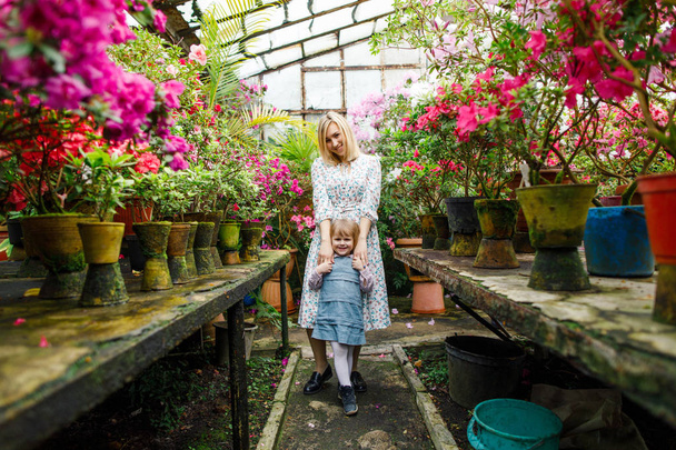 little girl in pink dress with flowers in the garden - Foto, Bild