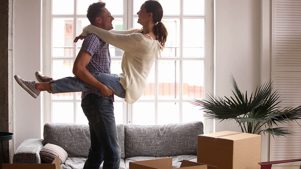Feliz pareja celebrar el día de mudanza en su propio piso con cajas
 - Imágenes, Vídeo