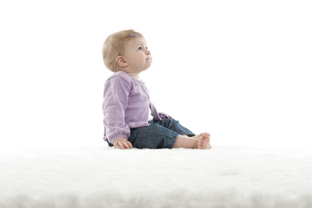 baby seated on a carpet , isolated on white background - Photo, Image