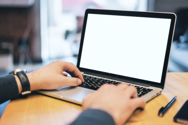 Man using white laptop screen on desktop - Фото, изображение
