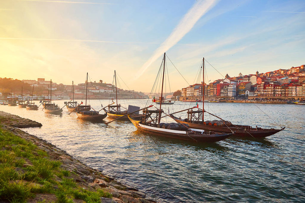 Typical portuguese wooden boats, called "barcos rabelos" transporting wine barrels on the river Douro with view on Villa Nova de Gaia  in Porto, Portugal - Photo, Image