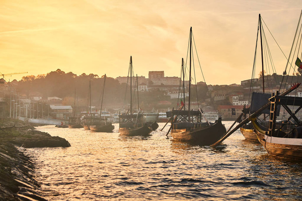 Typical portuguese wooden boats, called "barcos rabelos" transporting wine barrels on the river Douro with view on Villa Nova de Gaia  in Porto, Portugal - Photo, Image