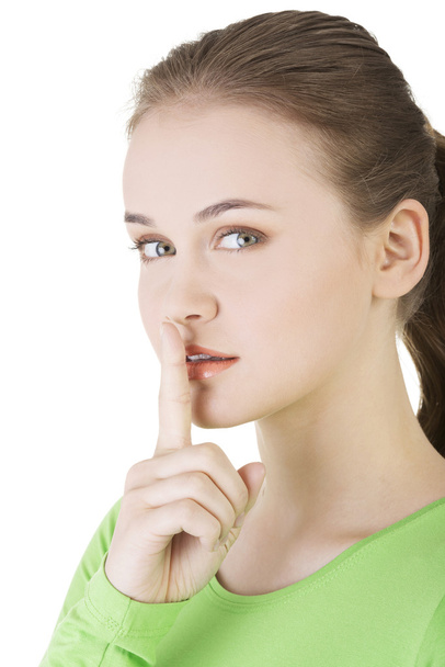 Hush be quiet woman isolated. Teen girl with finger on her lips. - Photo, image